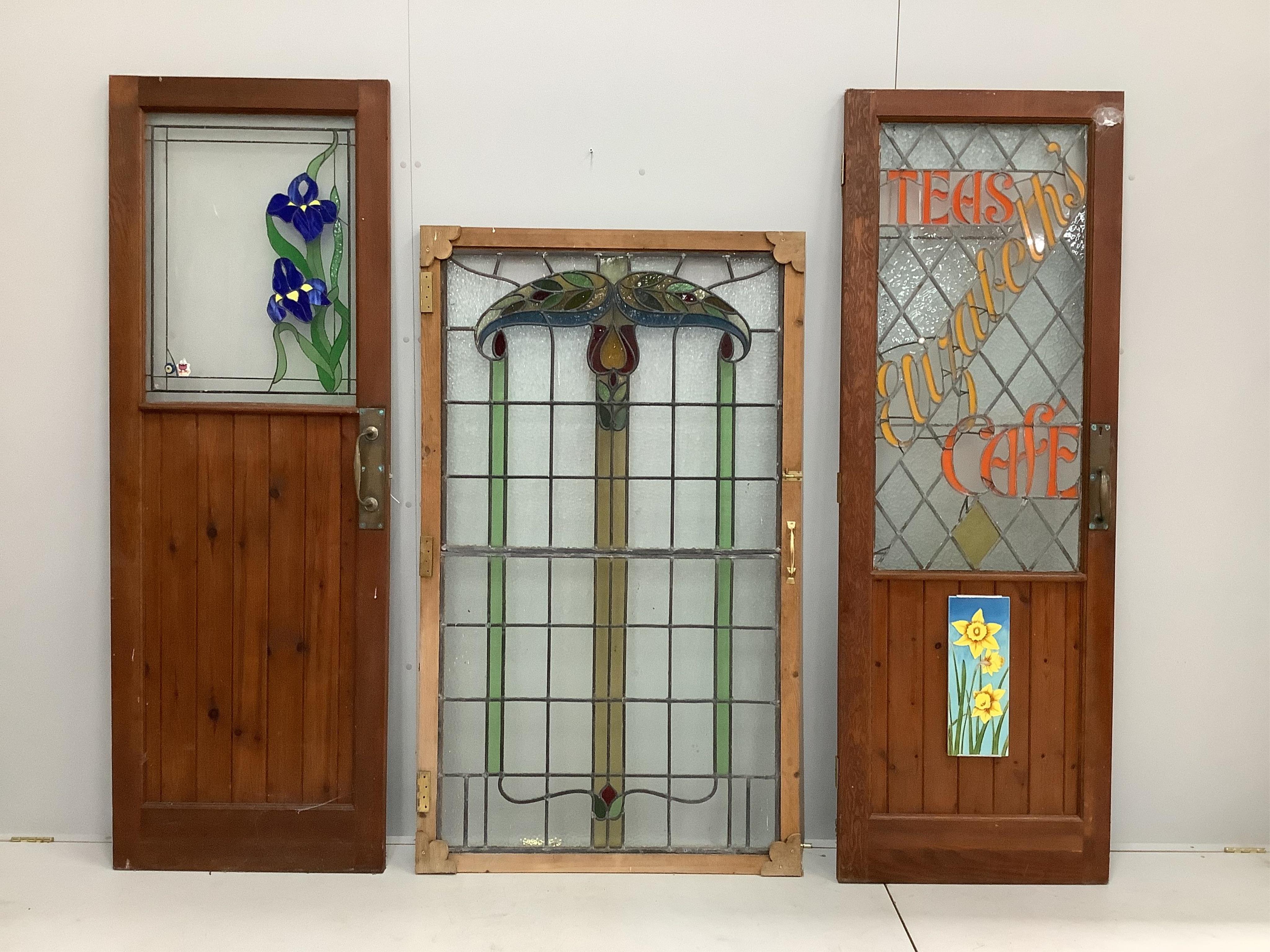 Three early 20th century and later stained glass doors, largest width 97cm, height 164cm